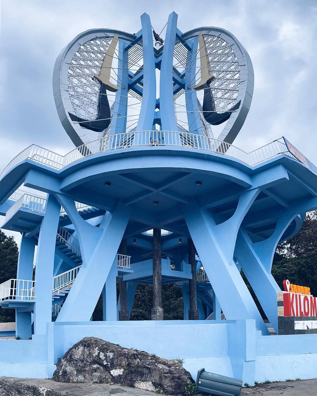 The blue Kilometer Zero Indonesia monument in Sabang on Pulau Weh, under a cloudy sky