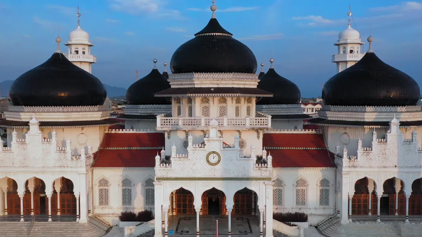 Baiturrahman Grand Mosque in Banda Aceh seen from the air, its black domes above white arcades